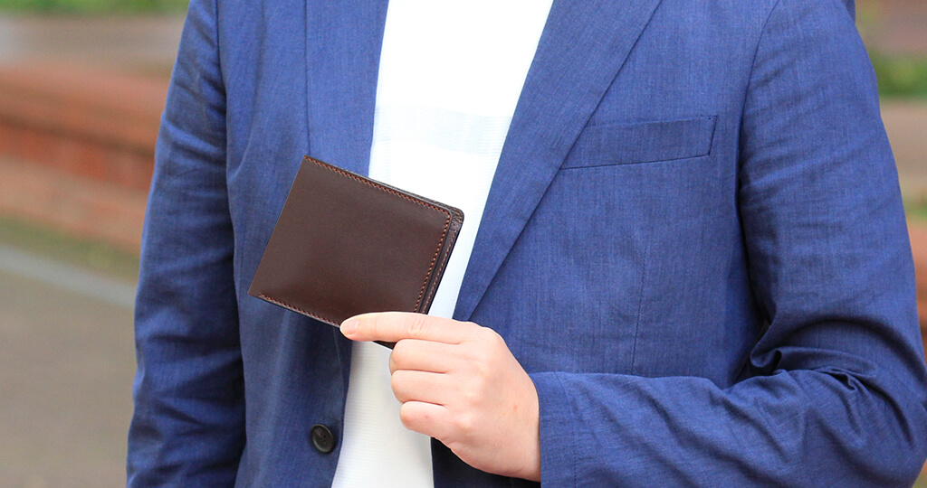 男の人がかっこよく二つ折り財布を持っているイメージ画像